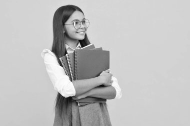 Okula dönelim. Kitabı öğrenmeye hazır ergen bir kız öğrenci. İzole edilmiş sarı stüdyo geçmişi olan liseli kızlar. Mutlu kız yüzü, pozitif ve gülümseyen duygular