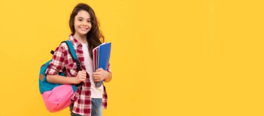 Okula kitap ve sırt çantası taşıyan mutlu bir kız, okul. Öğrenci pankartı. Kopya alanı olan öğrenci portresi