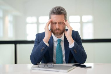 Dizüstü bilgisayarı olan üzgün adamın ağrısı yüzünden migreni tuttu. Baş ağrısı olan bir adam. Çok çalışan bir serbest çalışan ya da yönetici.