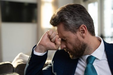 Aşırı yorgun adam migren ağrısı çekiyor. Sıkılmış iş adamının ofis sendromu var. Migreni ya da baş ağrısı olan bitkin bir adam. Ofis çalışanı, yönetici ya da serbest çalışan birinin başı ağrıyor.