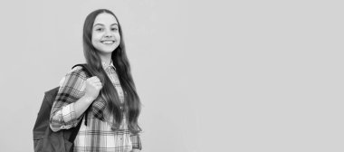 happy kid in checkered shirt with school bag on yellow background, school. Banner of school girl student. Schoolgirl pupil portrait with copy space