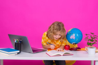 Okul öğrencisi sınıfta öğreniyor, okulda İngilizce öğreniyor. İlkokul çocuğu. Komik bir öğrencinin portresi.