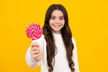 Sarı izole edilmiş arka planda lolipopu olan komik çocuk. Tatlı çocukluk hayatı. Lezzetli karamel lolipopu olan genç kız, şekerci. Mutlu yüz, pozitif ve gülümseyen genç kız duyguları