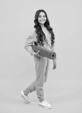 Eşofmanlı kız. Sarı takım elbiseli, sarı arka planda mutlu şirin bir çocuk. Spor giysileri reklam konsepti