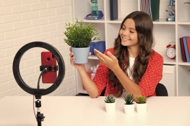 Young blogger girl recording video for blog. Teen girl speaking in front of camera for vlog. Teenager working as blogger, recording video tutorial for blog. Happy girl , positive and smiling emotions