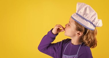 Kid cook with cooking pot and ladle. Child in cook uniform. Chef kid isolated on yellow background. Cute child to be a chef. Child dressed as a chef hat