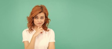 Mavi arka planda kıvırcık saçlı kızıl saçlı bir kadın. İzole edilmiş yüz portresi, kopyalama alanı olan pankart