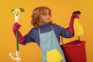 Çocuk ev işlerine yardım ediyor, evi temizliyor. Aksesuar temizleme, temizlik malzemeleri. Ev işlerine yardım eden, evi temizleyen çocuk portresi. Oda servisi, ev işleri.
