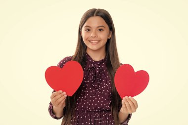 Mutluluk çocuklar ve aşk konsepti. Kırmızı kalpli romantik genç kız, dünya kalbi günü, mutlu sevgililer günü. Mutlu gülümseyen genç kızın portresi.