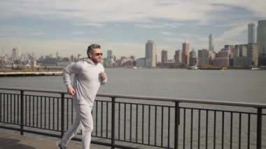 Koşucu dışarıda spor antrenmanında koşuyor. New York 'ta sabah sporu koşucusu. Sporcu adam koşuyor. Manhattan 'da koşan adam. Koşucu uzun spor koşusunda. Yavaş çekim.