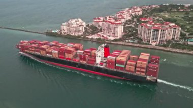 Miami, Florida, ABD - 17 Haziran 2024: Kargo konteynırı Miami 'de yüklendi. Limandan ayrılan hava görüntülü kargo gemisi. Konteyner gemisi. Miami 'de konteynırlı bir kargo gemisi. Balıkçı Adası.