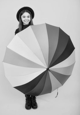 Happy teenager portrait. Smiling girl. Happy teenager portrait. Child teenager girl with rainbow umbrella on yellow background