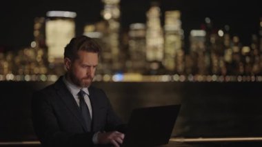 Adam internet tarayıcısından iş e-postası ve sörf yolluyor. New York 'ta serbest çalışan bir iş adamı. İnternette çalışan bir iş adamı. İş adamı dışarıda bilgisayar ya da dizüstü bilgisayarda çalışmakla meşgul. Boşluğu kopyala.