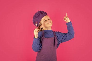 Çocuk aşçı kaşığı tut. Şef çocuk sağlıklı yemek hazırlıyor. Şef şapkalı çocuk portresi