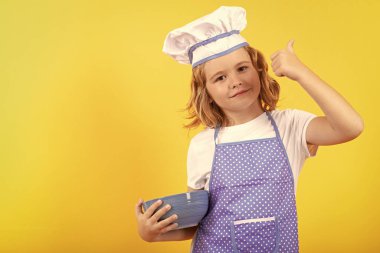 Aşçıbaşı aşçı çocuk. Heyecanlı aşçı şefi. Çocuk fırın üniforması ve aşçı şapkası giyiyor yemek hazırlıyor, stüdyo fotoğrafı çekiyor.