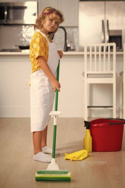 Child do chores cleaning floor. Child mopping house, cleaning home. Detergents and cleaning accessories. Cleaning service. Little boy housekeeping
