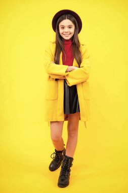 Güzel bir genç kızın tam boy fotoğrafı sarı arka planda izole edilmiş günlük sonbahar ceketi giyer. Mutlu ergen portresi. Gülümseyen kız