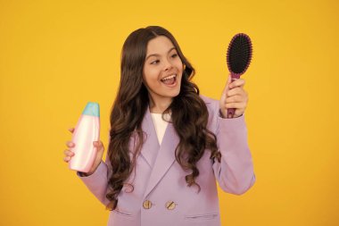 Şampuan kremi kullanan bir çocuk. Günlük kozmetik bakım. 12, 13, 14 yaşlarındaki ergen çocuğun elinde saç ve cilt bakımı şişesi var. Güzellik sağlığı ve kozmetik ürünleri. Mutlu yüz, pozitif ve gülümseyen