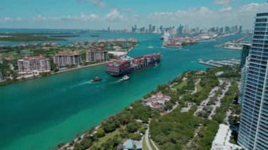 Miami, Florida, ABD - 23 Haziran 2024: kargo gemisiyle Fisher Adası 'nı geçiyoruz. Kargo gemisi iskelede. Konteyner gemisi. Miami 'de konteynırlı kargo gemisi, hava manzaralı. Deniz nakliyesi.