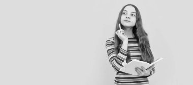 Düşünceli bir çocuk, elinde kalem ve defter sarı arka plan olan okul kompozisyonu üzerine düşünüyor. Liseli kız öğrenci pankartı. Kopya alanı olan öğrenci portresi