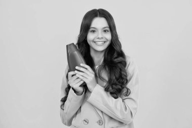 Genç kız şişe şampuanı ya da duş jeli gösteriyor. Saç kozmetik ürünü. Reklam için şişe fotokopi alanı oluşturun. Mutlu ergen, pozitif ve gülümseyen genç kız duyguları