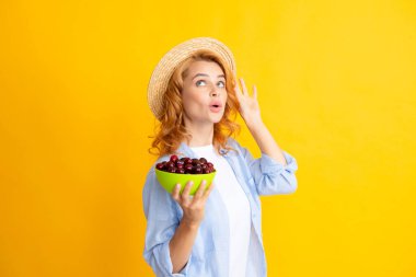 Woman with cherry, organic fruits. Cherries and harvesting in summer. Girl picking and eating ripe cherries, fresh fruits. Healthy organic berry cherry fruit, summer harvest season