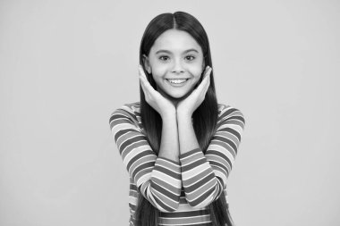 Happy face, positive and smiling emotions of teenager girl. Emotional portrait of caucasian teenager child girl isolated on studio yellow background