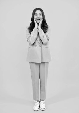 Uzun boylu, neşeli, neşeli bir genç kız. Keyfi yerinde ve sarı arka planda izole edilmiş günlük kıyafetlerle poz veriyor. Mutlu ergen, pozitif ve heyecanlı genç kız duyguları