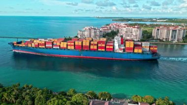 Miami, Florida, ABD - 29 Haziran 2024: konteyner gemisi. Miami 'de konteynırlı kargo gemisi, hava manzaralı. Kargo gemisindeki nakliye konteynırı Fisher Adası 'nı geçiyor. Kargo gemisi. Ekspres nakliye.