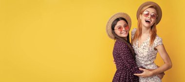 Mother and daughter kid banner, copy space, isolated background. positive mother and child in straw hat on yellow background