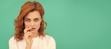 İzole edilmiş bir yüz resmi, kıvırcık saçlı seksi bir kız mavi arka planda mükemmel bir teni var, fotokopi alanı, cilt bakımı. İzole edilmiş yüz portresi, kopyalama alanı olan pankart