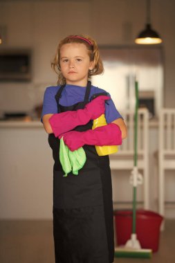 Çocuk temizlik için toz bezi ve eldiven kullanıyor. Komik çocuk paspas evi. Aksesuar temizleme, temizlik malzemeleri. Oda servisi ve ev temizliği.