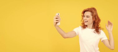 Woman isolated face portrait, banner with mock up copy space. Image of excited happy young woman isolated overyellow background make selfie by camera