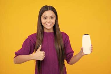 Teenage girl with shampoos conditioners or shower gel. Kids hair care cosmetic product, shampoo bottle