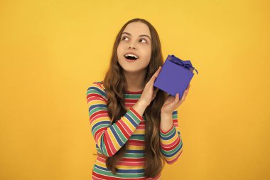 Funny kid girl in winter wear holding gift boxes celebrating happy New Year or Christmas. Winter holiday. Excited face, cheerful emotions of teenager girl