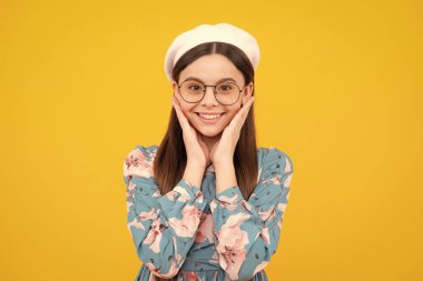 Stüdyonun sarı arka planında izole edilmiş Kafkas ergen kız çocuğunun duygusal portresi. Mutlu ergen, pozitif ve gülümseyen duygular