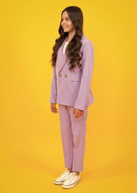 Sarı arka planda izole edilmiş rahat moda kıyafetleri giyen neşeli ergen kız çocuğu. Moda çocukları takımı. Mutlu ergen, pozitif ve gülümseyen genç kız duyguları