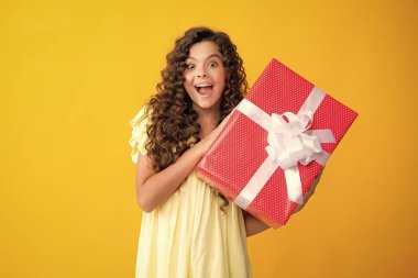 Child with gift present box on isolated background. Presents for birthday, Valentines day, New Year or Christmas. Excited teenager, glad amazed and overjoyed emotions