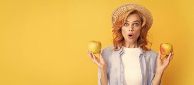 Elmalı yaz modeli. yaz hasır şapkalı kıvırcık saçlı, elmalı, sağlıklı yiyecekli genç bir kadın. İzole edilmiş yüz portresi, taklit alanı olan pankart