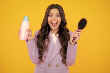 Şampuan kremi kullanan bir çocuk. Günlük kozmetik bakım. Gençlerin elinde saç ve cilt bakımı şişesi var. Güzellik sağlığı ve kozmetik ürünleri. Heyecanlı genç kız