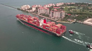Miami, Florida, ABD - 17 Haziran 2024: Kargo konteynırı Miami 'de yüklendi. Limandan ayrılan hava görüntülü kargo gemisi. Konteyner gemisi. Miami 'de konteynırlı kargo gemisi, insansız hava aracı manzaralı. Gönderme.