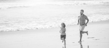 Banner of father and son run on summer sea beach. father and son running on summer beach with water, family.