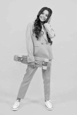 Teen school girl with skateboard on studio isolated background. Spring schoolgirl trend, urban teenager style