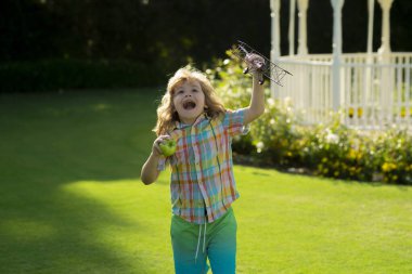 Happy childhood. Summer portrait of happy cute child. Enjoying life and nature. Little child boy is playing and dreaming of flying. Childhood concept. Little cute boy playing with a toy plane wings