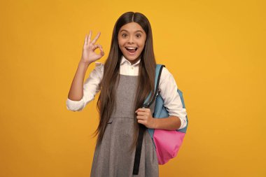 Back to school. Teenage school girl ready to learn. School children on yellow isolated background. Excited face, cheerful emotions of teenager girl