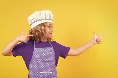 Portrait of little child in uniform of cook. Chef boy isolated on studio background. Cute child to be a chef. Child dressed as a chef hat