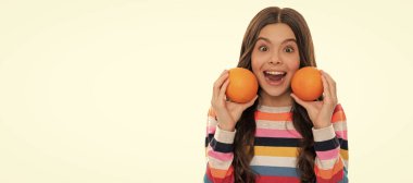 Süveterli, turuncu meyveli, beyaz, sağlıklı bir çocuk. Portakallı, yatay posterli çocuk portresi. Kopyalama alanı olan başlık