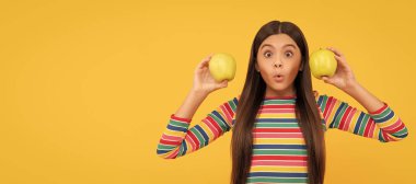 Günde elma yeterli değil. Elma tutan sürpriz kız. Sağlıklı olmak için elma yiyorum. Elmalı çocuk portresi, yatay poster. Kopyalama alanı olan başlık