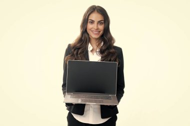 Beautiful smiling business woman over grey background using laptop computer. Woman holding laptop with empty mock up screen for copy space