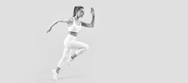 Spor kıyafetleri içinde koşan bir fitness kızı sarı arka planda. Kopyalama alanı ile çalışan kadın pankartı